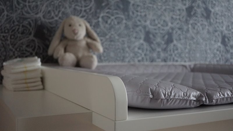 Wickelkommode mit Ablageplatz Wickelkommode mit Windeln und Kuscheltier