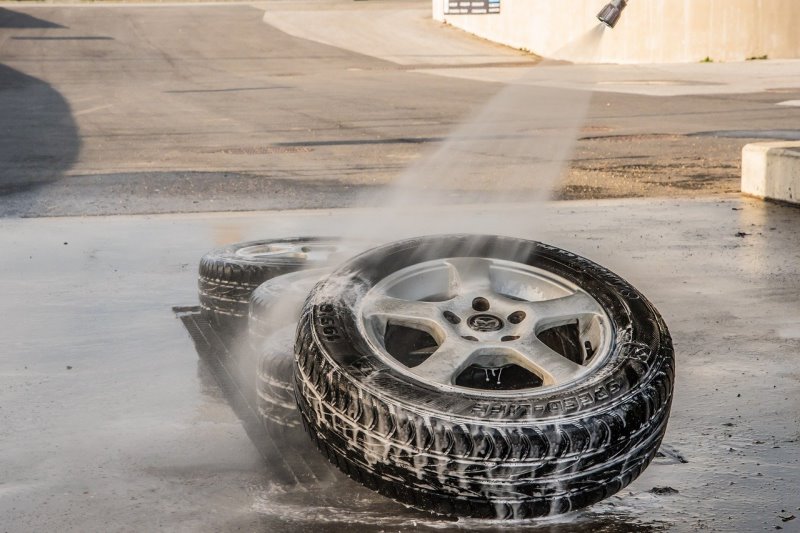 Abmontierte Felgen werden mit einem Wasserstrahl abgespült. Reinigung ohne Felgenreiniger im Test