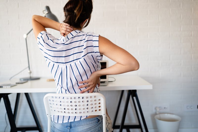 Eine Frau leidet während der Arbeit an Rückenschmerzen Chefsessel im Test