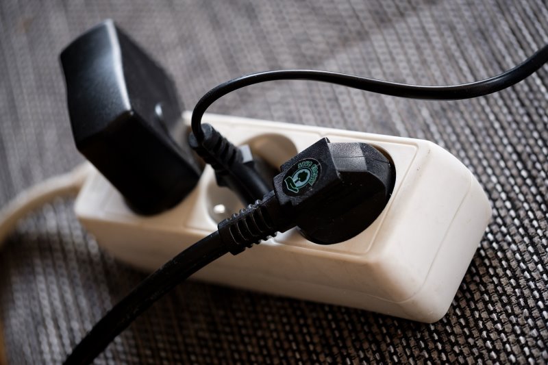 Steckdosenleiste mit drei Steckern Mehrfachsteckdose, an die drei Stecker angeschlossen sind