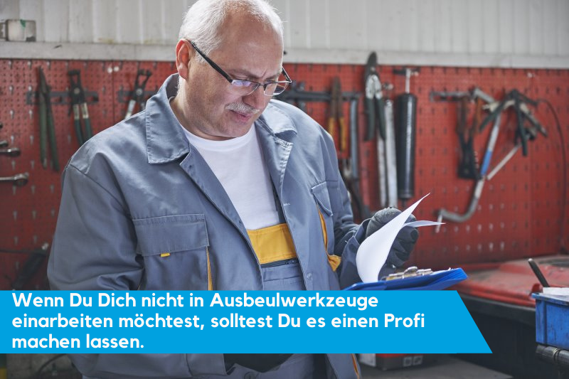 Mechaniker schaut auf sein Klemmbrett mit Info-Text