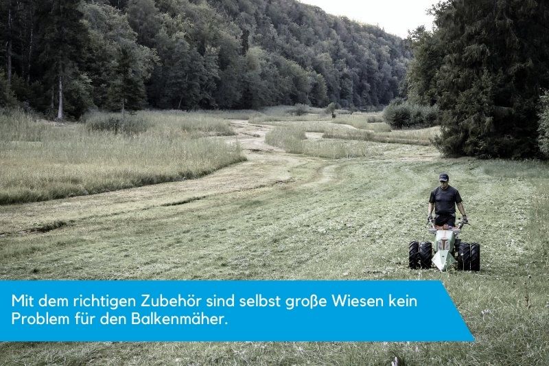 Mit Zubehoer ausgestatteter Balkenmaeher maeht grosse Wiese.